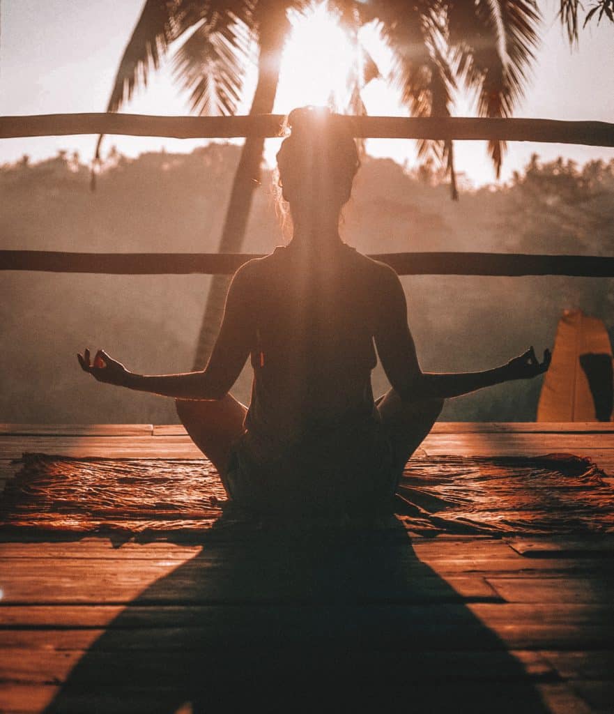 Woman meditating to release stress and experience personal growth.