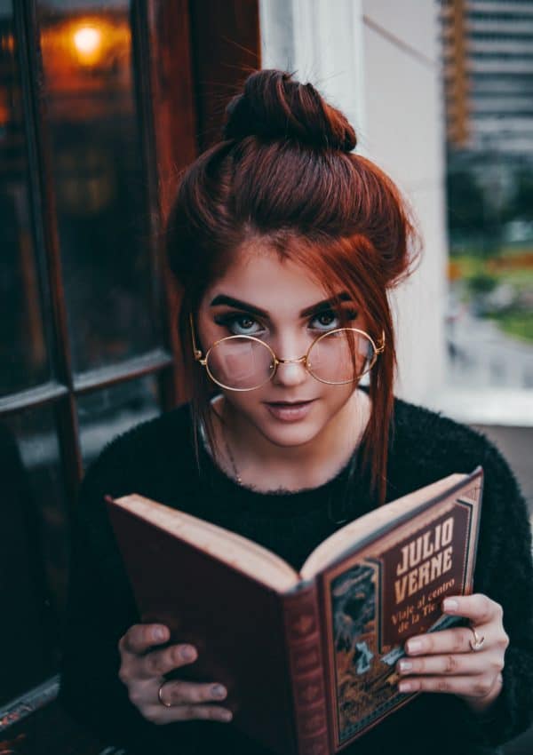 Young woman reading a book about the importance of personal growth.