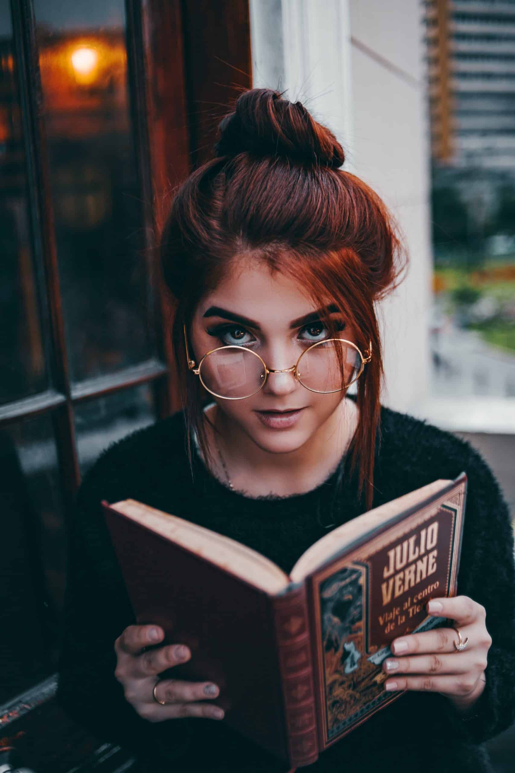 Young woman reading a book about the importance of personal growth.