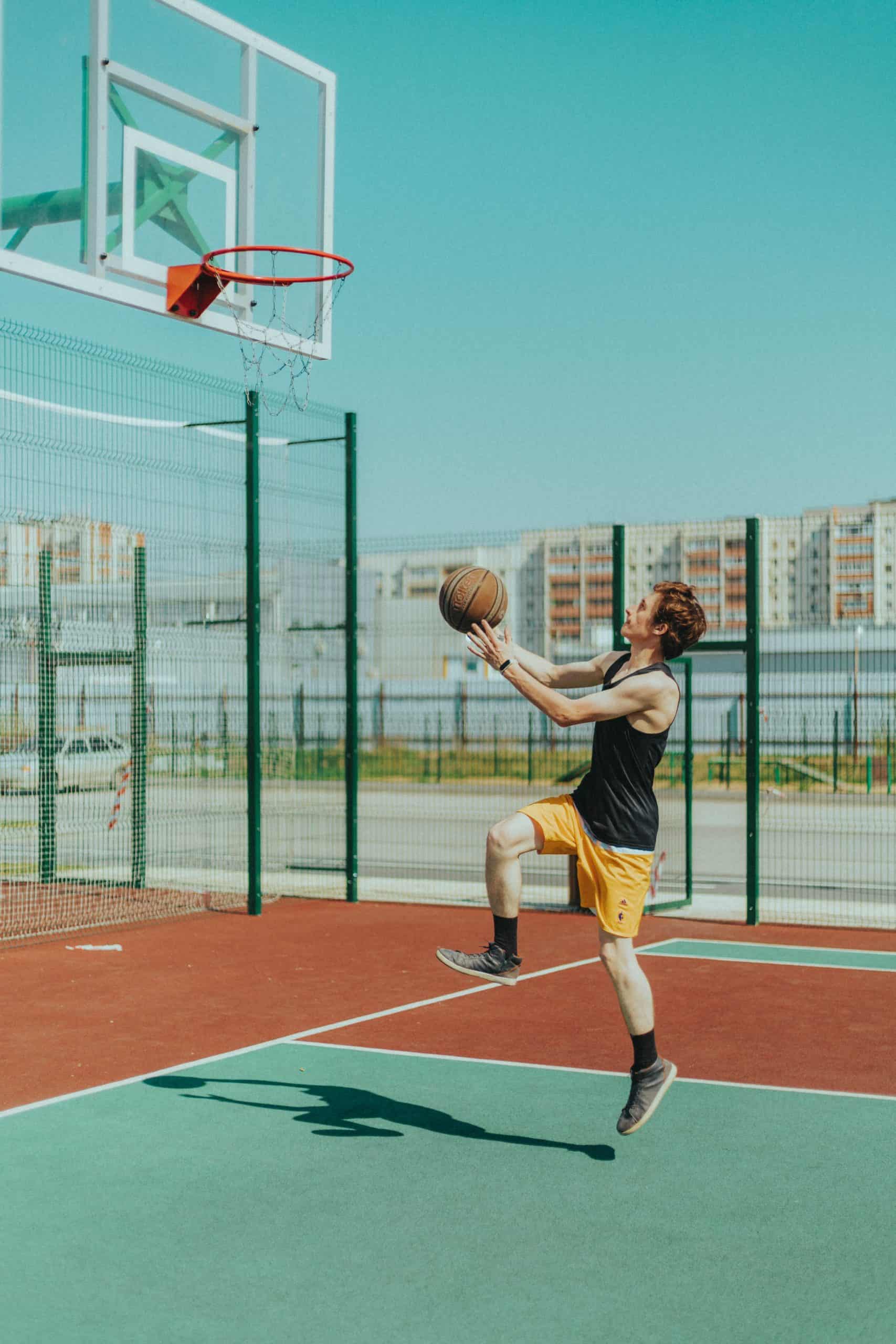 A man playing basketball which is a benefit of physical fitness for personal development